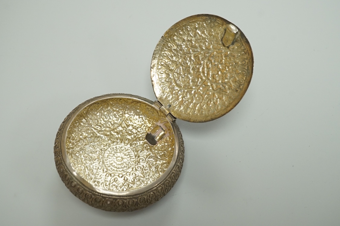 A Thai white metal tobacco box, embossed with foliage, diameter 72mm together with a similar dish.